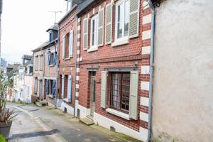 un edificio de ladrillo rojo con ventanas en una calle en Chez tonton Henri, maison de pêcheur, en Saint-Valery-sur-Somme