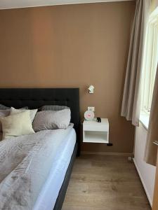 a bedroom with a bed with a nightstand and a window at Apartment in Hafnarfjörður in Hafnarfjördur