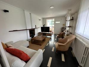 a living room with a couch and chairs and a television at Casa con piscina Irache in Ayegui