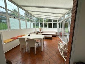 a conservatory with a table and chairs and a couch at Casa con piscina Irache in Ayegui