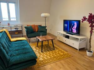 uma sala de estar com um sofá e uma televisão em Stadtmitte I Große Ferienwohnung I Parkplatz kostenlos em Rastatt
