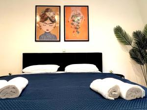 a bedroom with a blue bed with three pictures on the wall at Stadtmitte I Große Ferienwohnung I Parkplatz kostenlos in Rastatt