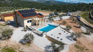 an overhead view of a house with a swimming pool and a house at Holiday house OLIVE LAND in Gustirna