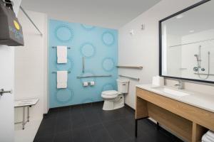 a bathroom with a toilet and a blue wall at Tru By Hilton Jacksonville Airport in Jacksonville