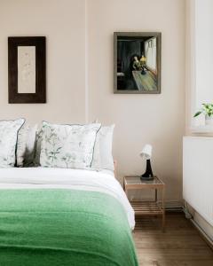 ein Schlafzimmer mit einem Bett mit einer grünen Decke in der Unterkunft Arty Escape in Central London - Zone 2 in London