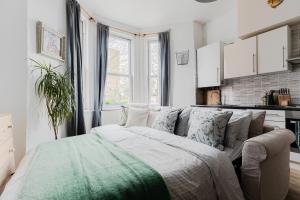 ein Wohnzimmer mit einem Bett und eine Küche in der Unterkunft Arty Escape in Central London - Zone 2 in London