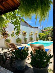 a patio with two chairs and a swimming pool at Pousada Maresia in São Miguel dos Milagres