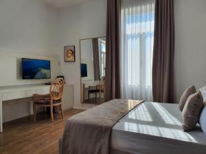 una camera con letto, scrivania e specchio di HEIRESS Hotel a Sarandë