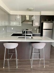 a kitchen with a white counter and two bar stools at Beautiful House in Brampton Area, ON Canada in Brampton