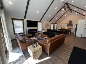 sala de estar con sofás de cuero y mesa en The Highmark Cabin en Valemount