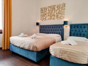2 Betten nebeneinander in einem Zimmer in der Unterkunft Residenza San Lorenzo Firenze in Florenz