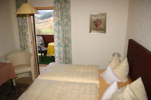 Schlafzimmer mit einem Bett, einem Tisch und einem Fenster in der Unterkunft Pension Hoisl in Schönberg