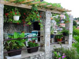 a pergola with plants and flowers on a patio at Apartments Boro in Splitska