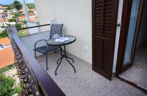 a table and a chair on a balcony at Apartments Boro in Splitska