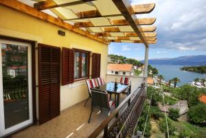 a balcony with a table and chairs and a view of the water at Apartments Boro in Splitska