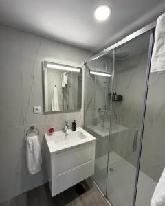 a white bathroom with a sink and a shower at Casa do Sorrio in Viana do Castelo