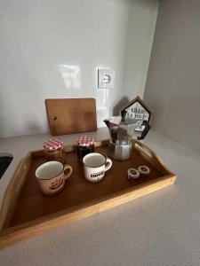 a tray with two coffee mugs and a box of jam at Casa do Sorrio in Viana do Castelo