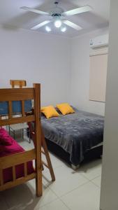 Un dormitorio con una cama y un ventilador de techo. en departamento 2 dormitorios Cinzano planta baja, en San Juan 4 fotos más