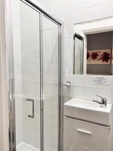 a bathroom with a shower and a sink and a mirror at The Grove in Weston-super-Mare