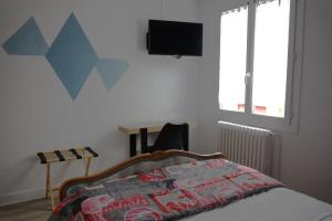 a bedroom with a bed and a television on the wall at Relais 375 in Couhé-Verac
