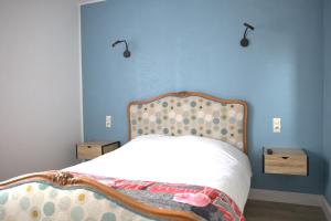 um quarto com uma cama com uma parede azul em RELAIS 375 em Couhé-Verac