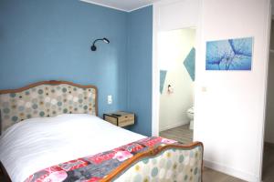 ein Schlafzimmer mit einem Bett und einer blauen Wand in der Unterkunft RELAIS 375 in Couhé-Verac