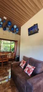 a living room with a brown couch and a table at Cabina monteverde Soan de Montaña in Monteverde Costa Rica