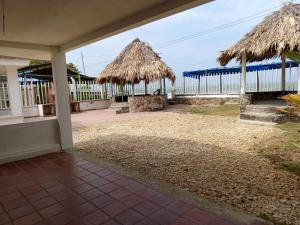 a patio with two thatched umbrellas on a house at Mary playas coveñas in Coveñas