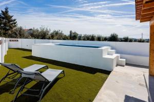 a backyard with a swimming pool and two chairs at Country Pool House 27 in Abrantes