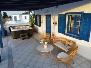 patio z wanną, krzesłami i stołem w obiekcie Giannis & Maria Sunset House w mieście Lagoúdi Zía