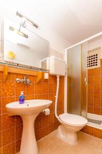 a bathroom with a sink and a toilet and a mirror at Apartments Verdun in Ivan Dolac +31 photos