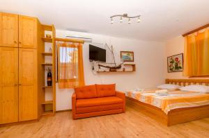 a bedroom with a bed and a chair at Apartments Verdun in Ivan Dolac