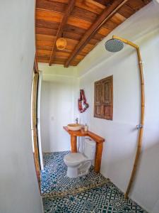 y baño con aseo y lavamanos. en Casa en la Playa Morro Paraiso, en Palomino
