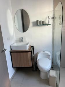 a bathroom with a toilet and a sink and a mirror at Caribbean View - Roosevelt #2 in Puerto Limón