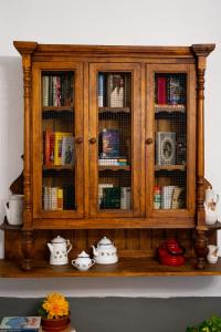 un armario de madera con libros y tazas en un estante en La bodega D'leti en Jarandilla de la Vera