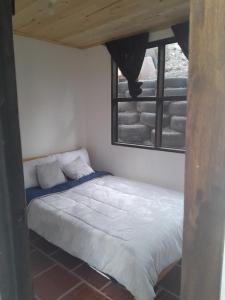 a bed in a room with a window at Hotel Mahoma in El Cocuy