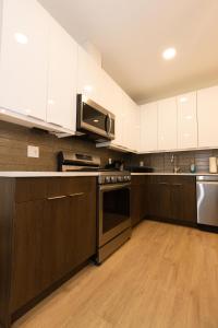 cocina con armarios blancos y fogones en Sleek City Haven-2BR Gem mins to NYC! en Union City
