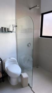 a white bathroom with a toilet and a shower at Caribbean View - Roosevelt #2 in Puerto Limón