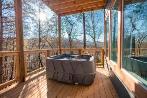 a hot tub on the deck of a tree house at Romantic Cabin Retreat By Ghosal Luxury Lodging in Gatlinburg
