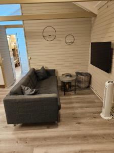 Relaxing and cozy cottage with hot tub في هوسافيل: غرفة معيشة مع أريكة وتلفزيون بشاشة مسطحة
