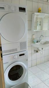 a washing machine in a bathroom with a sink at hoteliving am Bahnhof in Pohlheim