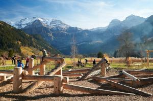 una valla de madera con montañas en el fondo en Chalet Alpenmoos (150m2 - max.11) en Lenk