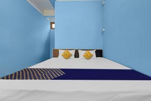 Bett in einem Zimmer mit blauer Wand in der Unterkunft OYO Hotel Garam Masala Residency in Guwahati