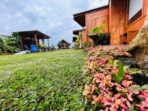 a garden with pink flowers next to a building at Buahan Sweet Glamping ( BSG) in Kubupenlokan