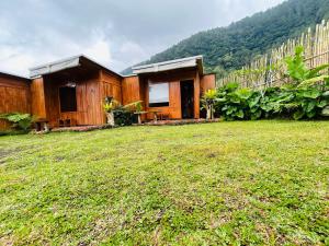 une maison avec une cour d'herbe devant elle dans l'établissement Buahan Sweet Glamping ( BSG), à Kubupenlokan