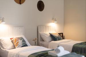 2 Betten in einem Zimmer mit weißer Bettwäsche und Kissen in der Unterkunft ZEM casolare in Petriolo