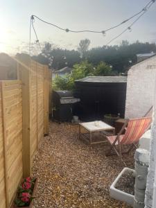 a small backyard with a grill and a chair at Beach Hideaway in Shanklin