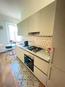 a kitchen with white cabinets and a stove top oven at Lucens Domus Appartamento Roma quartiere Trieste - vicino Metro b1 - in Rome