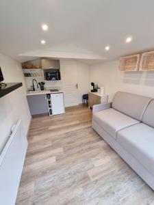 a living room with a white couch and a kitchen at Cosy Chalet - Disney - Val d'Europe - Vallée Shopping - Parrot World in Villiers-sur-Morin