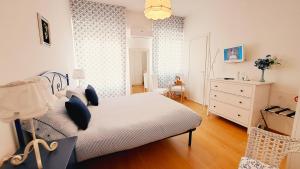 a bedroom with a white bed and a dresser at Affittacamere Zi Pasquale in Porto Recanati